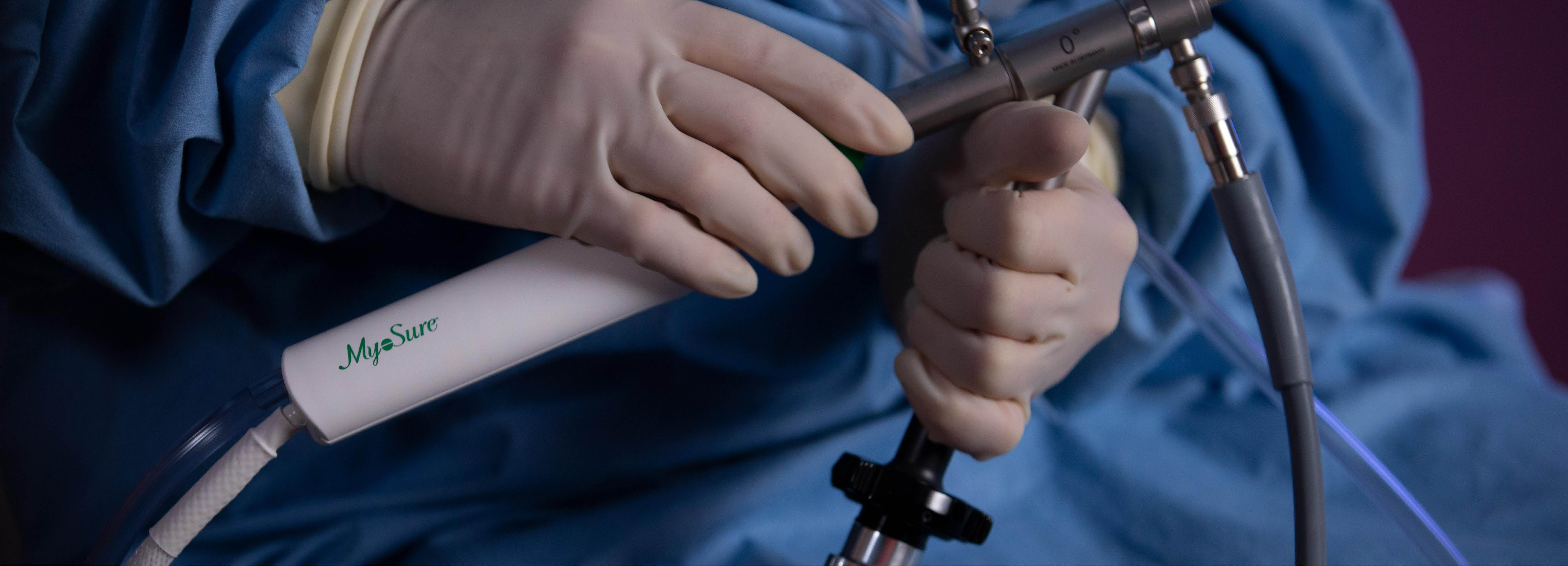 Mains gantées tenant un dispositif médical