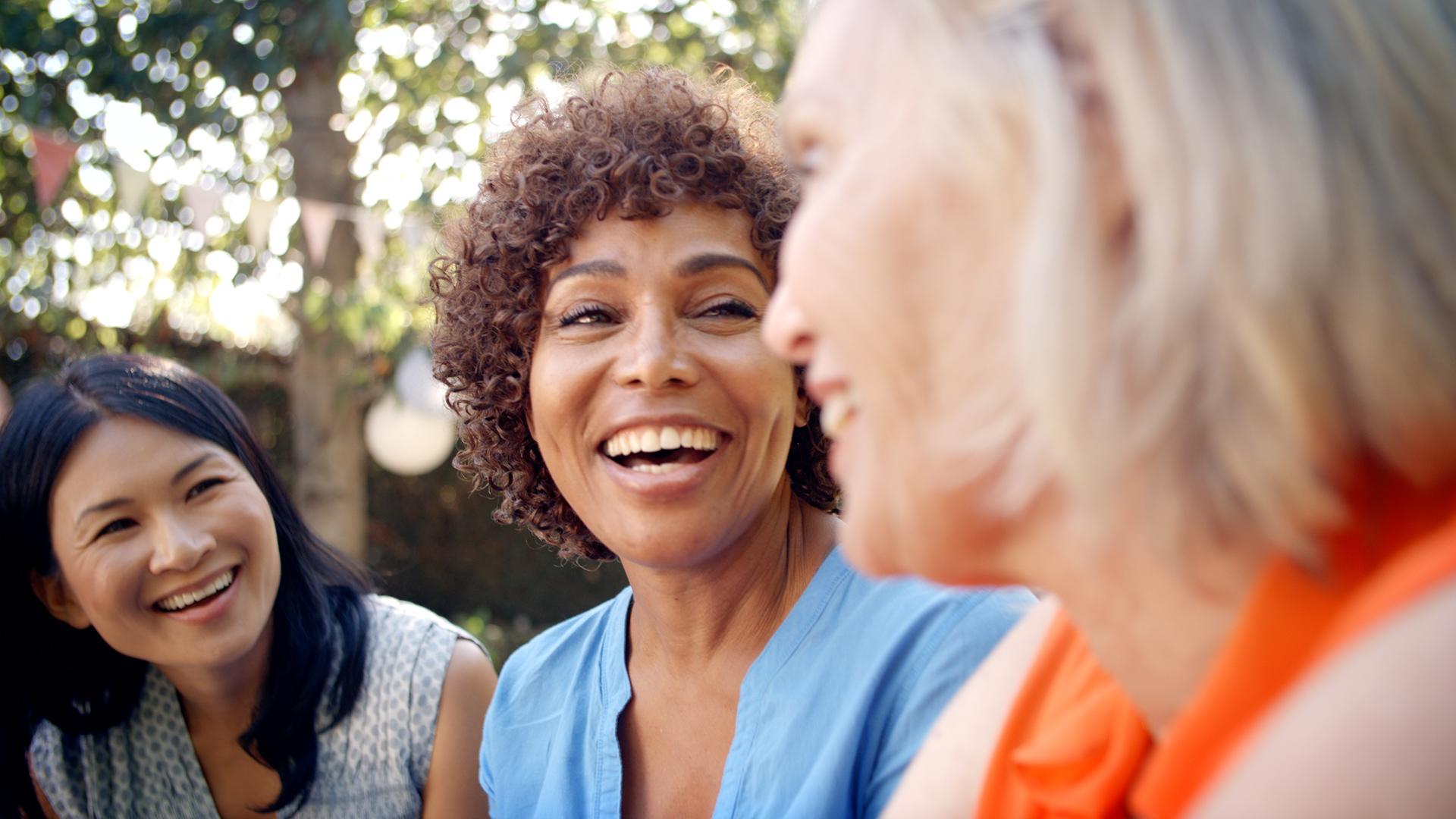 Trois femmes dehors se souriant