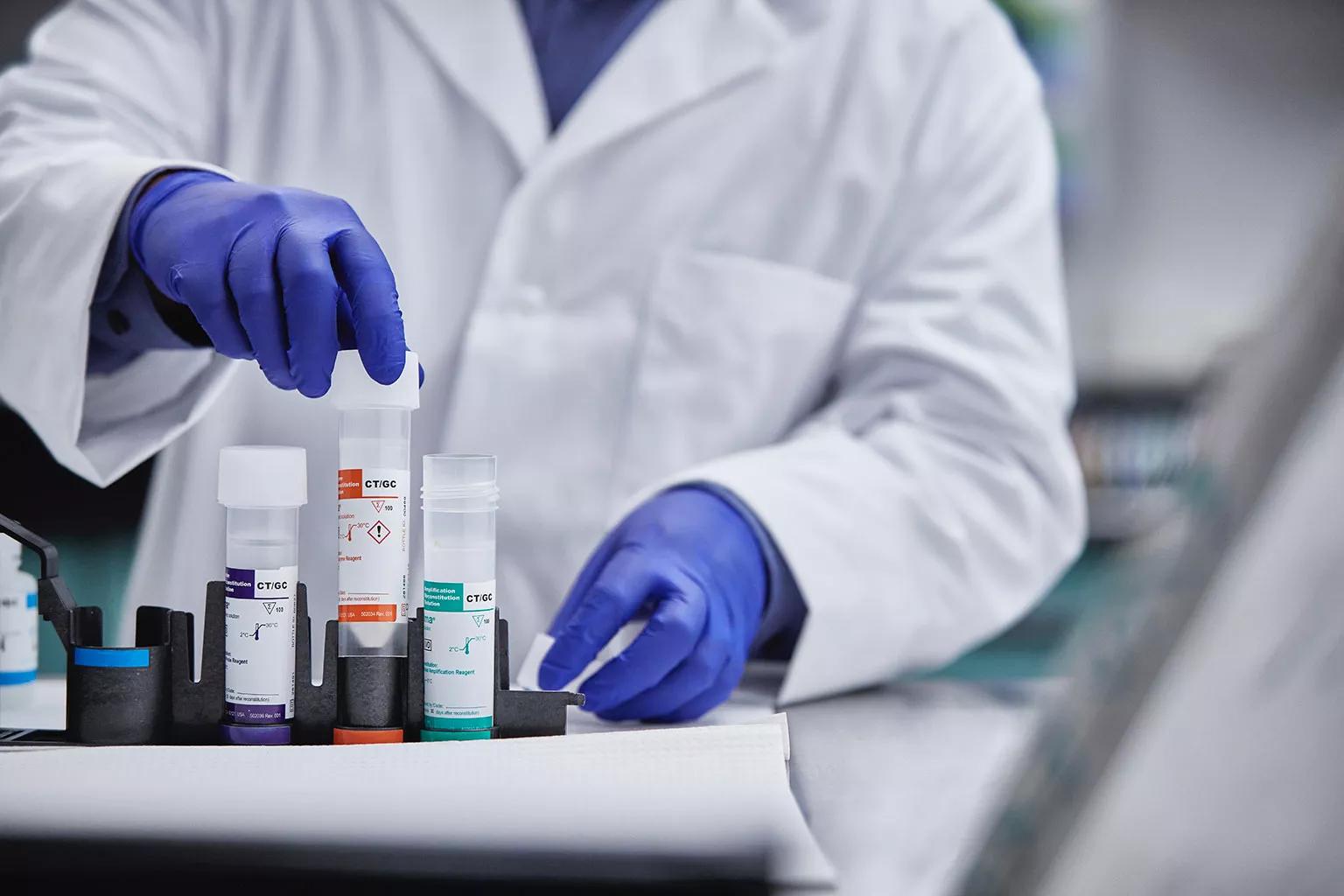 Un technicien de laboratoire soulève des tubes dans un laboratoire.