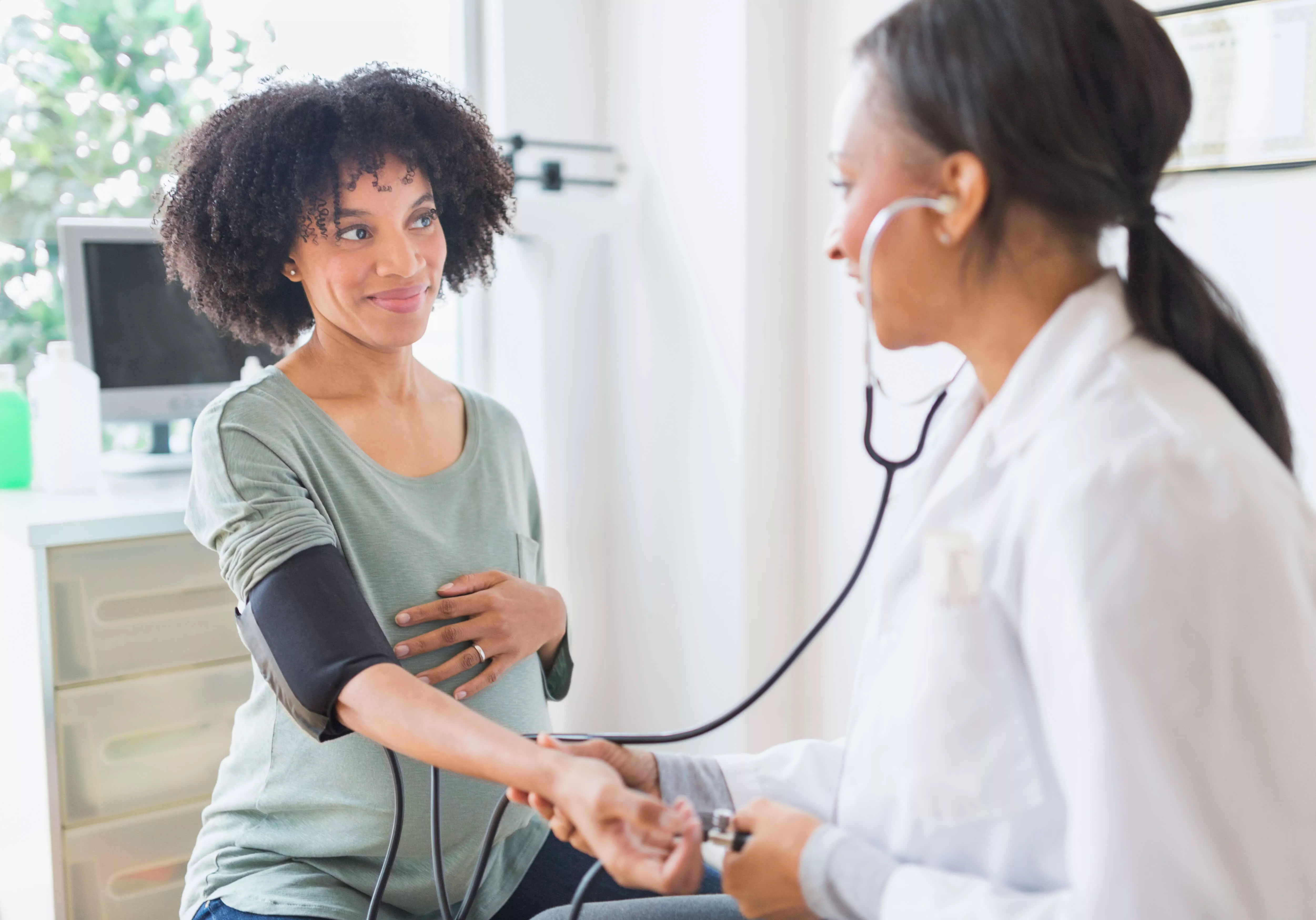 Une femme médecin place un stéthoscope sur le bras d’une femme.