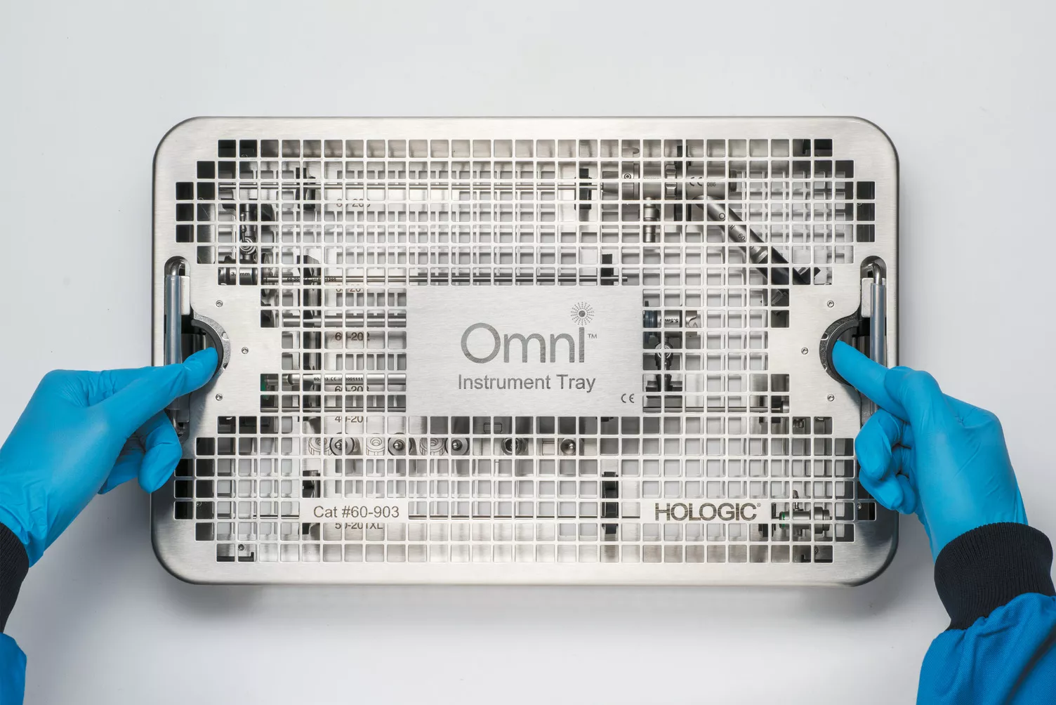 Des mains gantées travaillent sur un plateau médical posé sur une table.