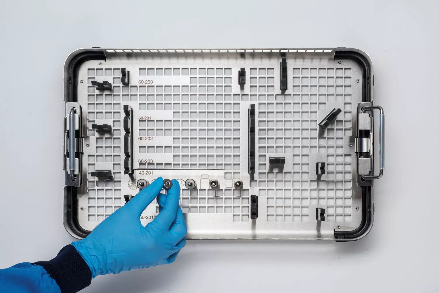 Main gantée travaillant sur un plateau médical posé sur une table.