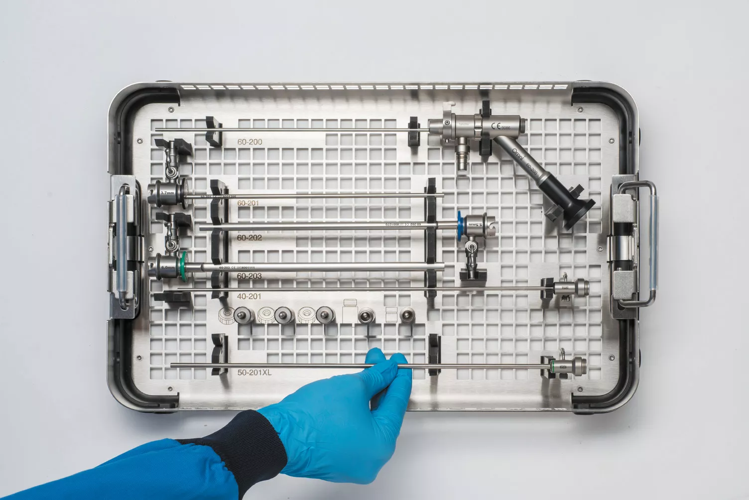 Main gantée travaillant sur un plateau médical posé sur une table.