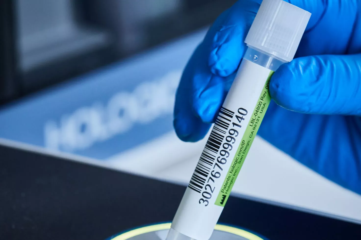 Gros plan d’une main gantée tenant un flacon